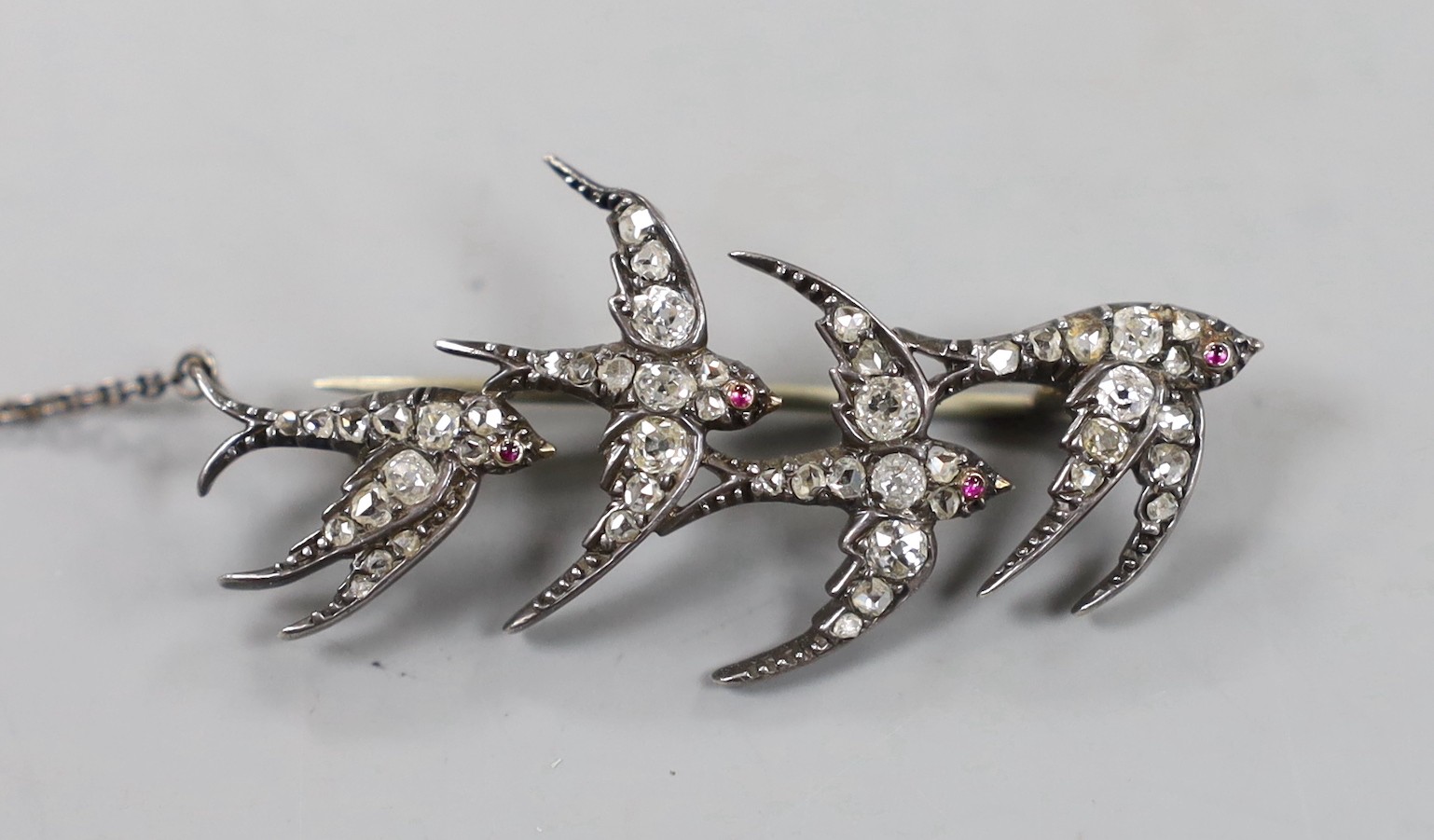 A Victorian yellow and white metal, cabochon ruby and old and rose cut diamond cluster set quadruple swallow brooch, with replaced pin, but original pin present, 47mm, gross weight 6 grams.